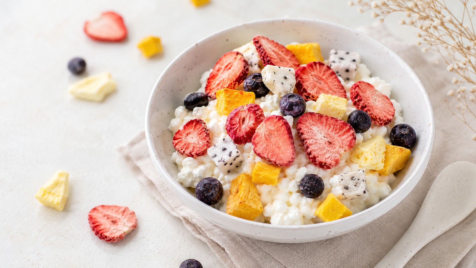Freeze-dried fruit sprinkled over cottage cheese in a soft pink snack-prep setting