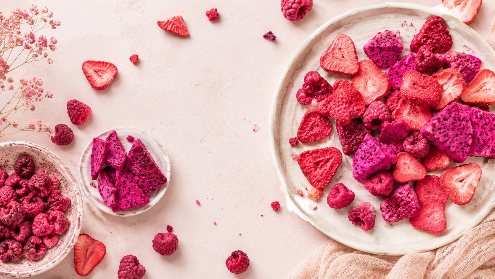 Freeze-dried fruit pieces in a pink and berry-toned flatlay styled for trail mix upgrades